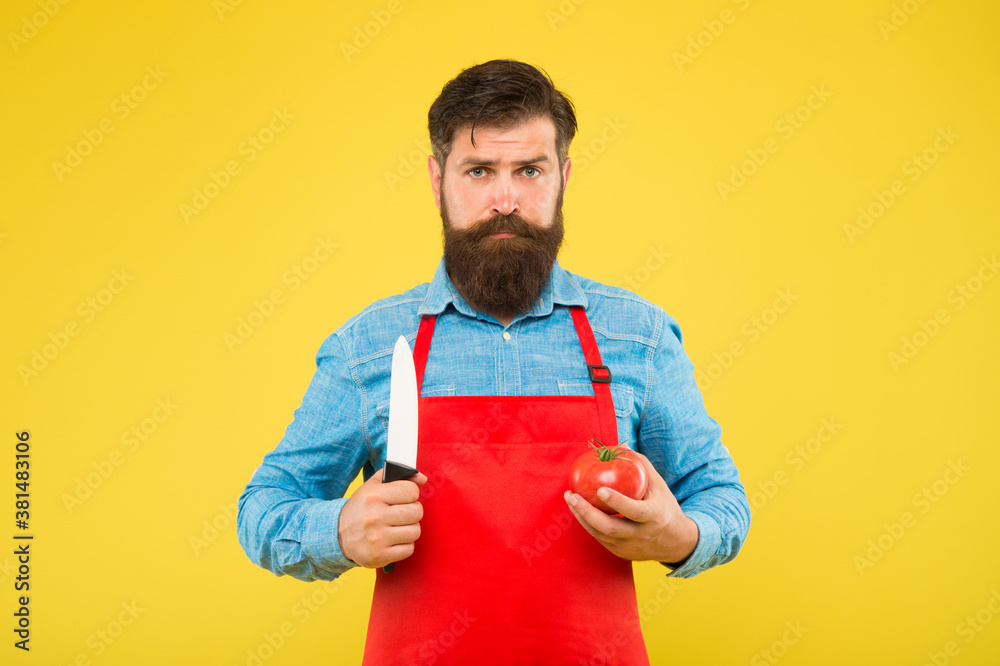 Serious hipster hold tomato and knife to cook fresh vegetable recipe for healthy diet, vegetarian Serious hipster hold tomato and knife to cook fresh vegetable recipe for healthy diet, vegetarian