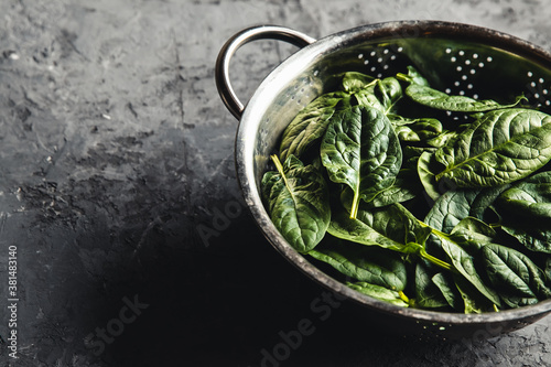 Fresh mini spinach in a colander on the old concrete table. Healthy food  eco product. Vegan