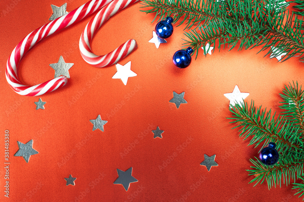 Christmas composition. Christmas decorations, fir tree branches on red background with stars. Flat lay, top view, copy space. Christmas, winter, new year concept.
