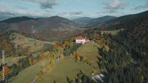 Pictorial recreation complex hotel building surrounded by mixed forests large meadows on highland aerial. Carpathian mountains, Ukraine beauty nature. Travel, summer holidays, resort, recreation. 4K photo