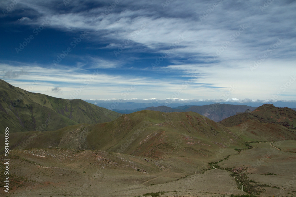 Aerial view of popular landmark Bishop's slope in Salta, Argentina. The green field, valley and hills under a beautiful blue sky with clouds. Aerial view of popular landmark Bishop's slope in Salta, Argentina. The green field, valley and hills under a beautiful blue sky with clouds.