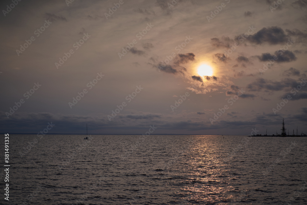 sunset on the beach with orange sun and glare on the water sunset on the beach with orange sun and glare on the water