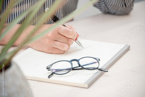 Candid close up image of a young female worker taking notes.