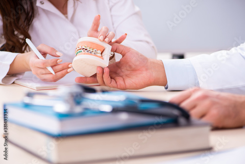 Young male doctor stomatologist and female student in the classr