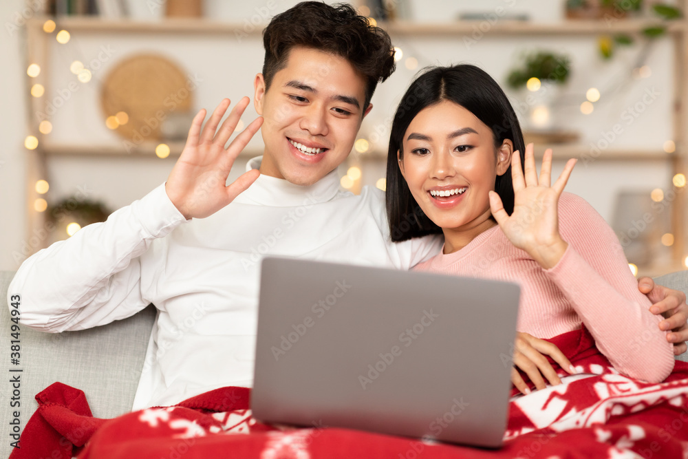 Happy Asian Couple With Laptop Celebrating Christmas Online At Home Happy Asian Couple With Laptop Celebrating Christmas Online At Home