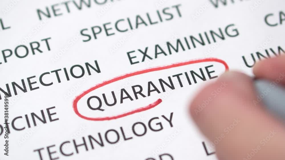 Hand tracing word quarantine in the red marker on white paper. Close-up Hand tracing word quarantine in the red marker on white paper. Close-up