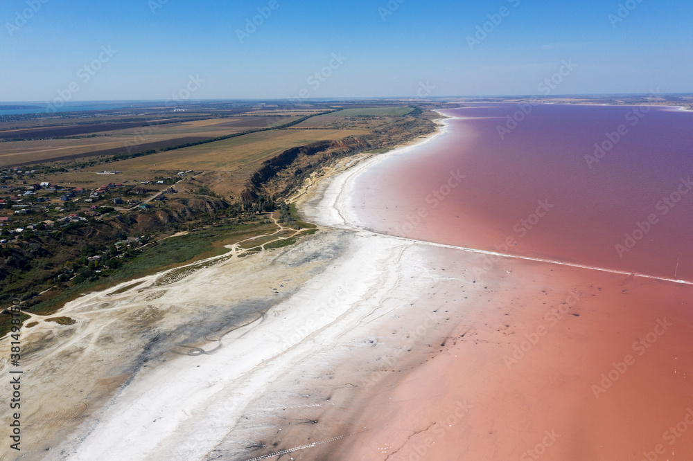 Aerial drone top down photo of a natural pink lake Kuyalnik in Odessa, Ukraine. Lake naturally turns pink due to salts and small crustacean Artemia in the water. This miracle is rare occurrence.