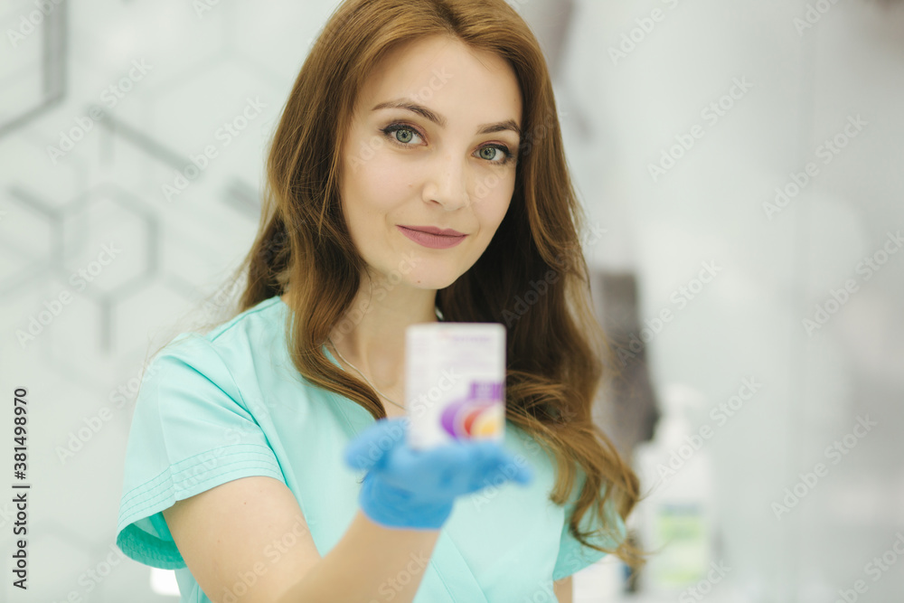 Cosmetologist hold cosmetic product in hand. Attractive medical worker