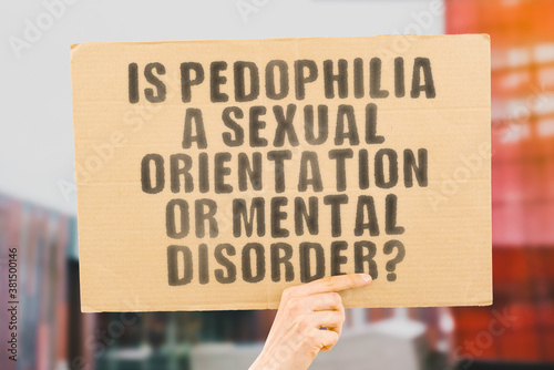 Vászonkép The question  Is pedophilia a sexual orientation or mental disorder?  on a banner in men's hand with blurred background