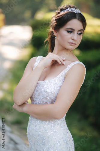 Portrait of young bride in white wedding dress outdoors. Fashion makeup