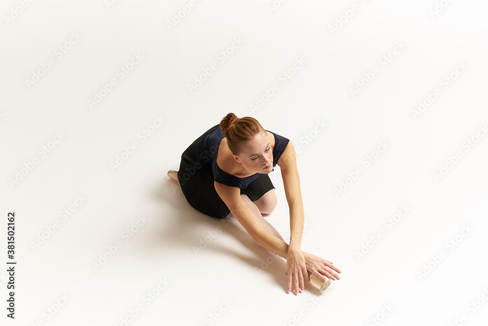 Ballerina in pointe shoes and in a tutu on a light background dance correct positioning of the legs slim figure 