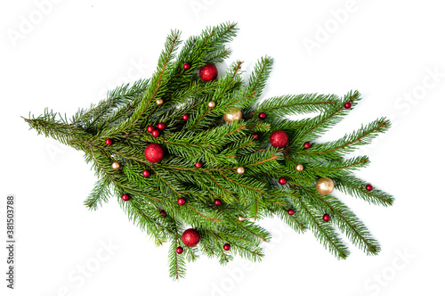 Christmas branch of a natural tree with red and gold balls on a white background close-up. Isolate