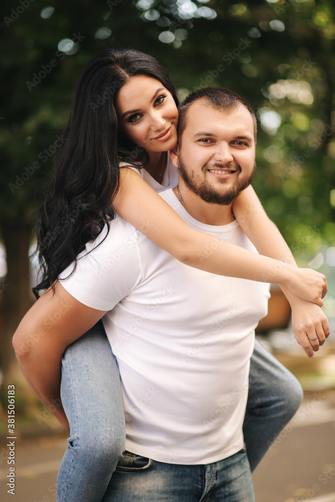 Beautiful gilr climbed on her boyfriend back and hug him. Happy smiled couple spend time in city Beautiful gilr climbed on her boyfriend back and hug him. Happy smiled couple spend time in city