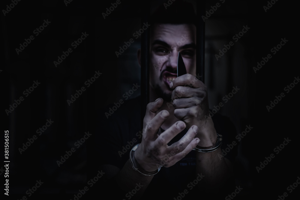 Portrait of aggressive handcuffed man imprisoned for crime, punished for serious villainy. Arrest, gangster, pain concept.