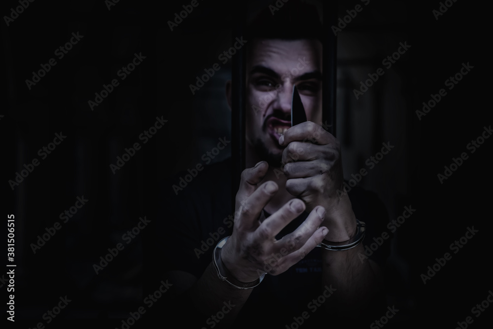 Portrait of aggressive handcuffed man imprisoned for crime, punished for serious villainy. Arrest, gangster, pain concept. Portrait of aggressive handcuffed man imprisoned for crime, punished for serious villainy. Arrest, gangster, pain concept.