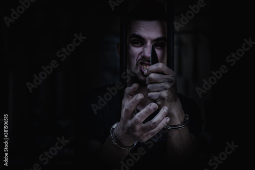Portrait of aggressive handcuffed man imprisoned for crime, punished for serious villainy. Arrest, gangster, pain concept. © zwiebackesser