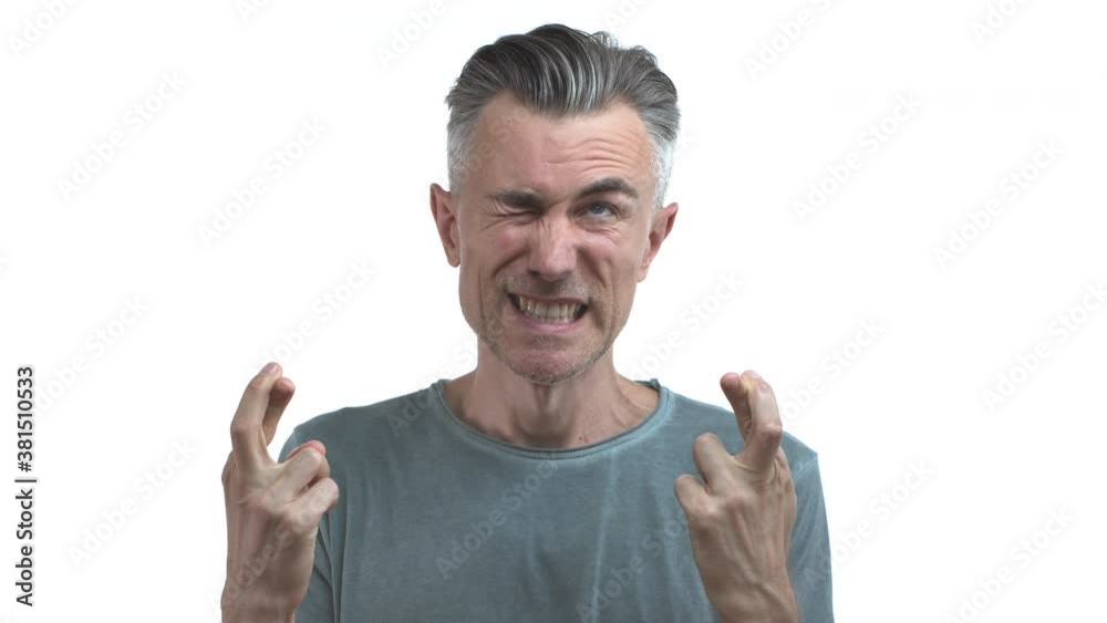 Handsome adult guy with grey hair and bristle, wearing casual clothes, looking optimistic while making wish, cross fingers for good luck, waiting for relish, standing over white background Handsome adult guy with grey hair and bristle, wearing casual clothes, looking optimistic while making wish, cross fingers for good luck, waiting for relish, standing over white background