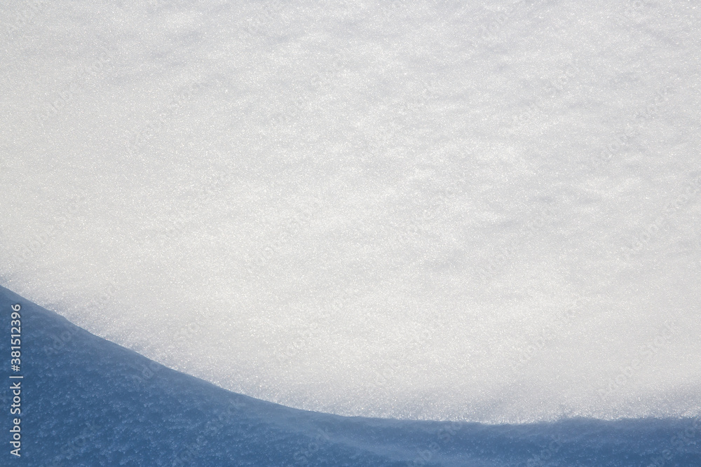 Obraz premium Beautiful winter background with snowy ground. Natural snow texture. Wind sculpted patterns on snow surface. Closeup top view with copy space.