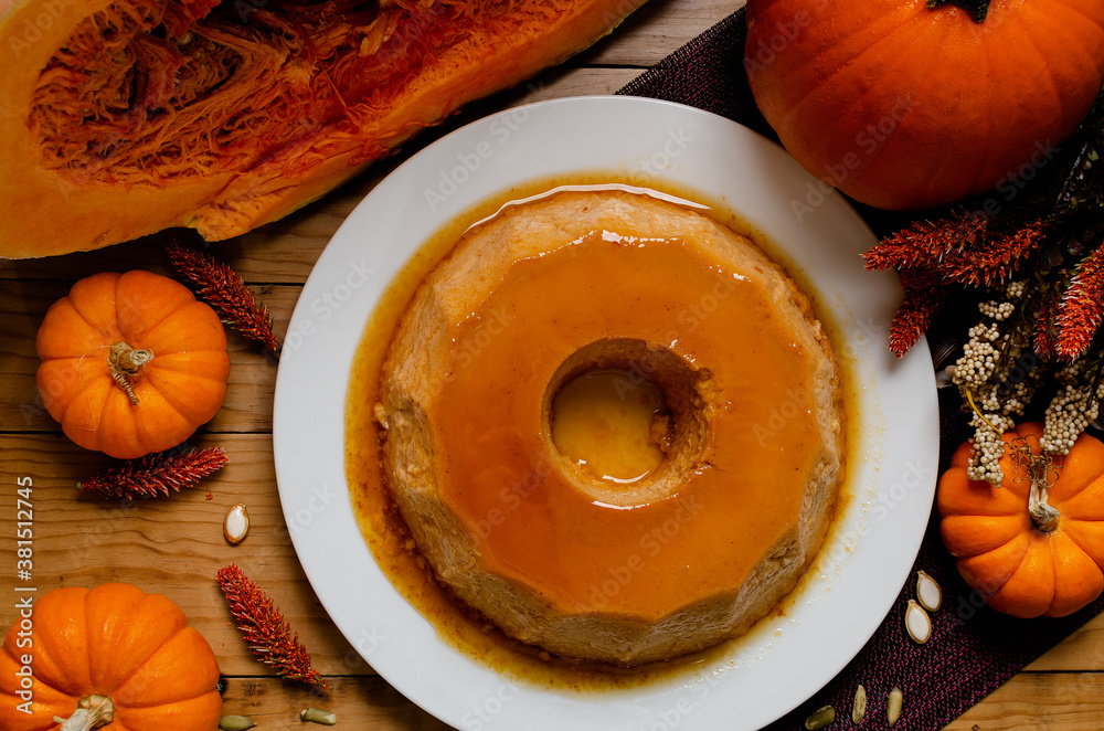 Pumpkin flan, dessert made for the Day of the Dead. Dessert on wooden table with autumn decoration around. Pumpkin flan, dessert made for the Day of the Dead. Dessert on wooden table with autumn decoration around.