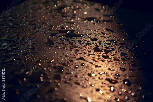 Rain drops on the illuminated surface . Night pluvial texture