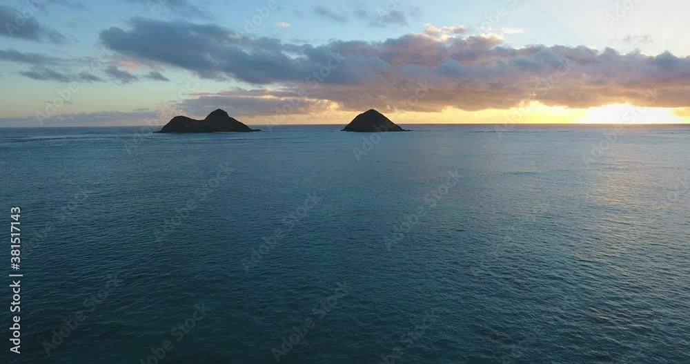 Wide aerial, colorful sunset behind islands in Hawaii Wide aerial, colorful sunset behind islands in Hawaii