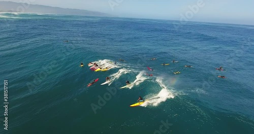 Large crowd of surfers catch wave in Hawaii, aerial photo