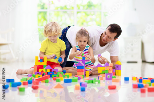 Kids play with toy blocks. Family at home.