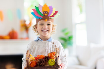 Child on Thanksgiving. Kid with autumn turkey hat.
