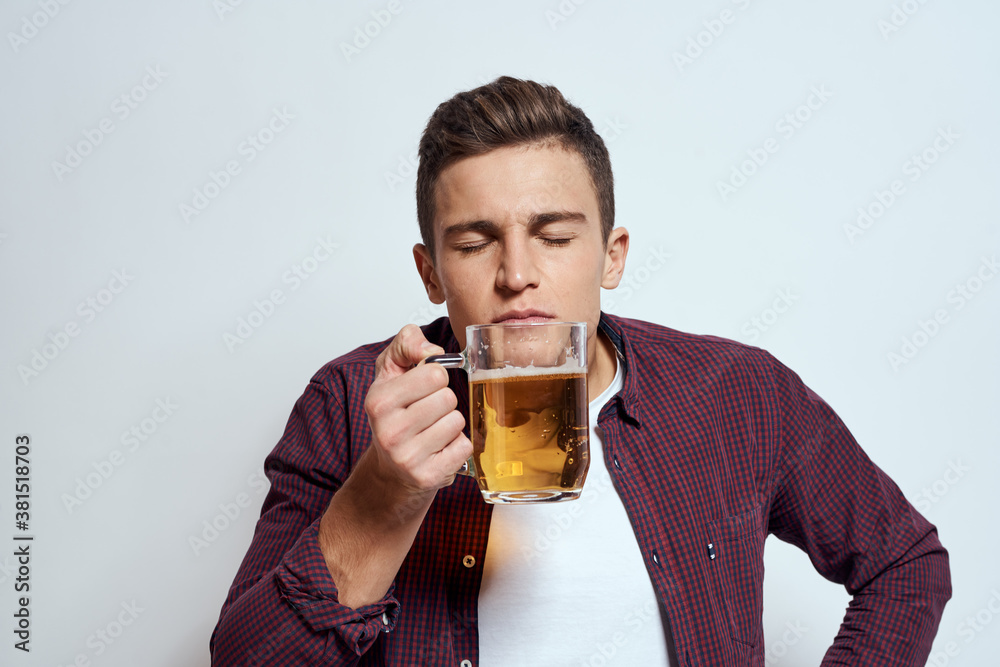 Drunk man with a mug of beer vacation alcohol lifestyle in a red shirt emotions light background Drunk man with a mug of beer vacation alcohol lifestyle in a red shirt emotions light background