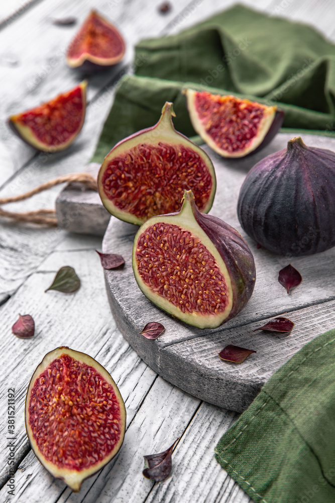 Fototapeta Juicy ripe figs. Whole fruit and cut into halves. Healthy, fortified, dietary food.