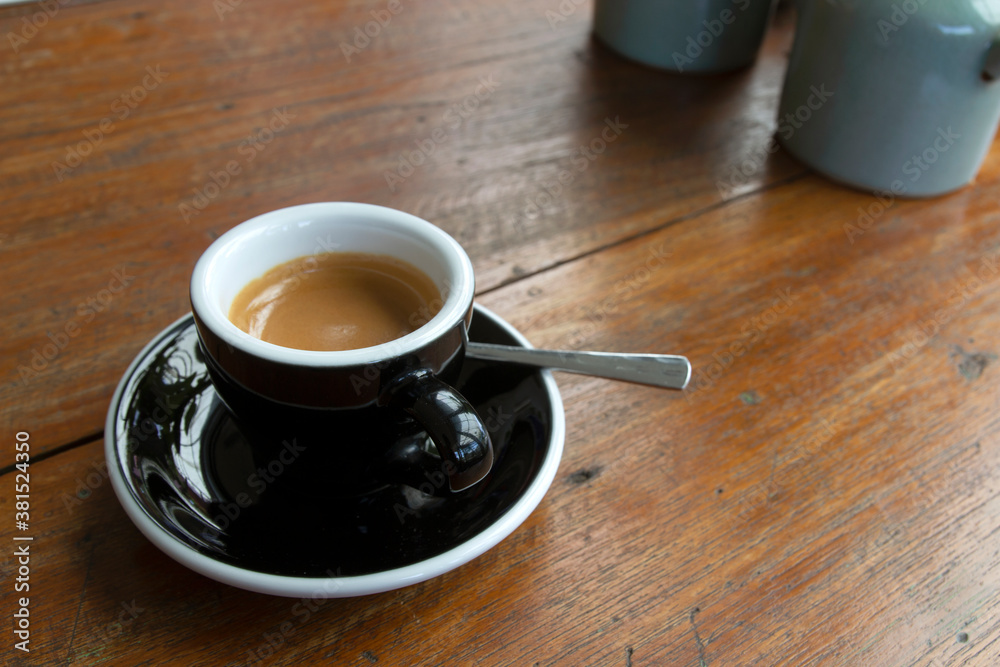 Obraz premium Black coffee in a cup on a wooden table