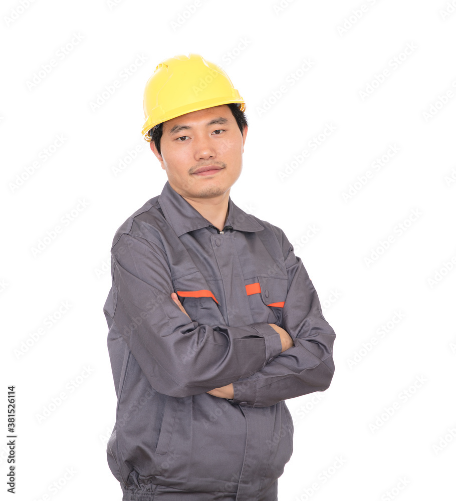 Migrant worker wearing yellow hard hat holding hands standing in front of white background Migrant worker wearing yellow hard hat holding hands standing in front of white background