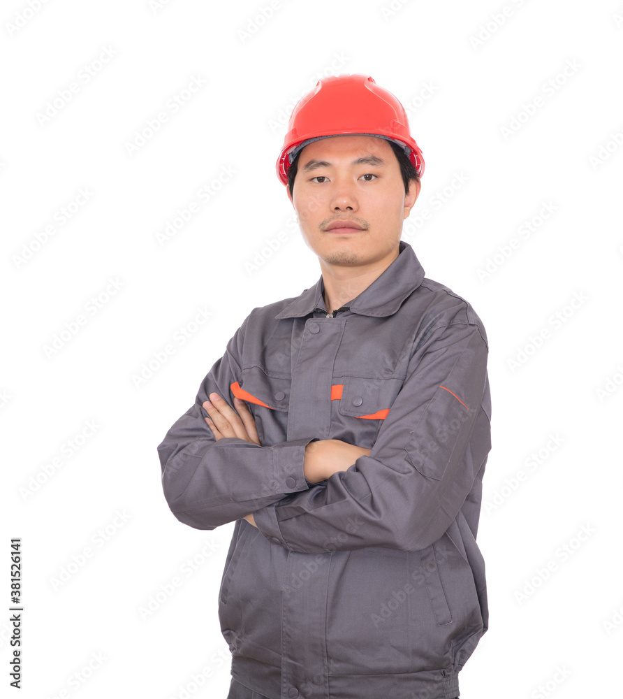 Migrant worker wearing red hard hat standing in front of white background holding hands Migrant worker wearing red hard hat standing in front of white background holding hands
