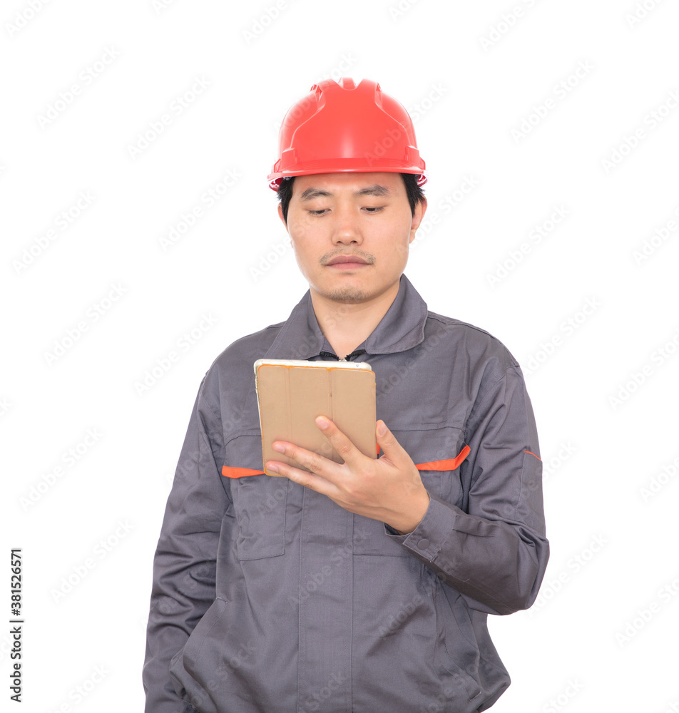 Construction worker with red hard hat holding ipad in hand standing in front of white background Construction worker with red hard hat holding ipad in hand standing in front of white background