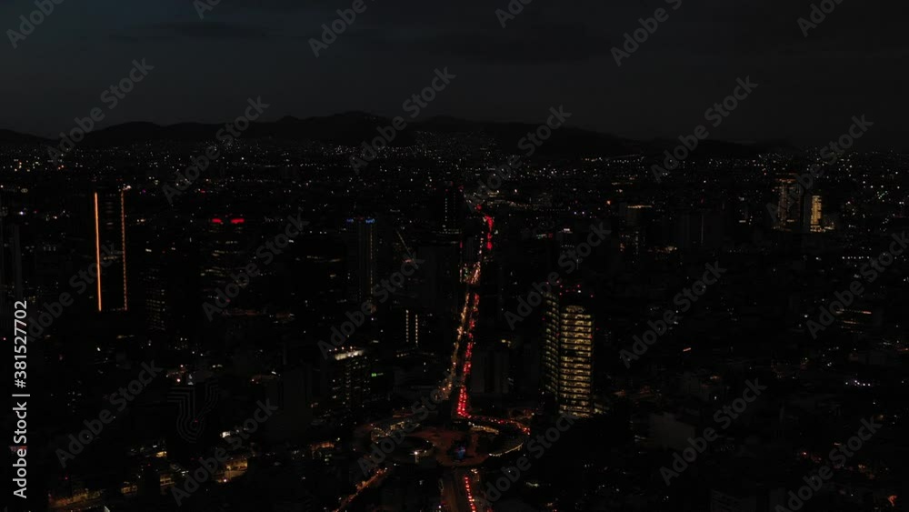 Vista aérea nocturna del tráfico vehicular sobre Av. Insurgentes sur a la altura de la Glorieta de Insurgentes. El drone volando al frente