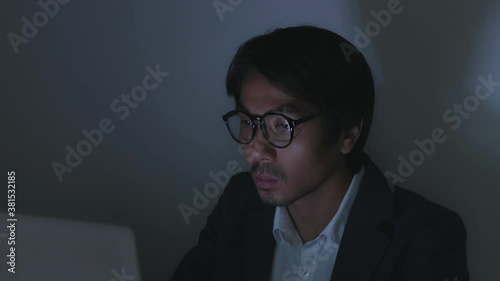 Asian Insurance Agent Businessman in Suit Wear Glasses Typing Laptop and Working Late at Office in Normal View