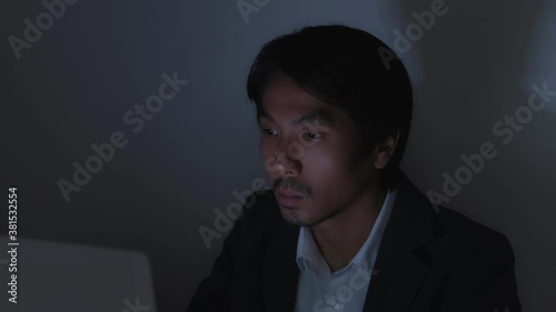 Asian Insurance Agent Businessman in Suit Typing Laptop Working Late at Office in Normal View