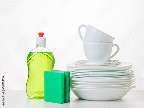 Quadro su tela A set of clean dishes, gel and a set of foam sponges on a white table