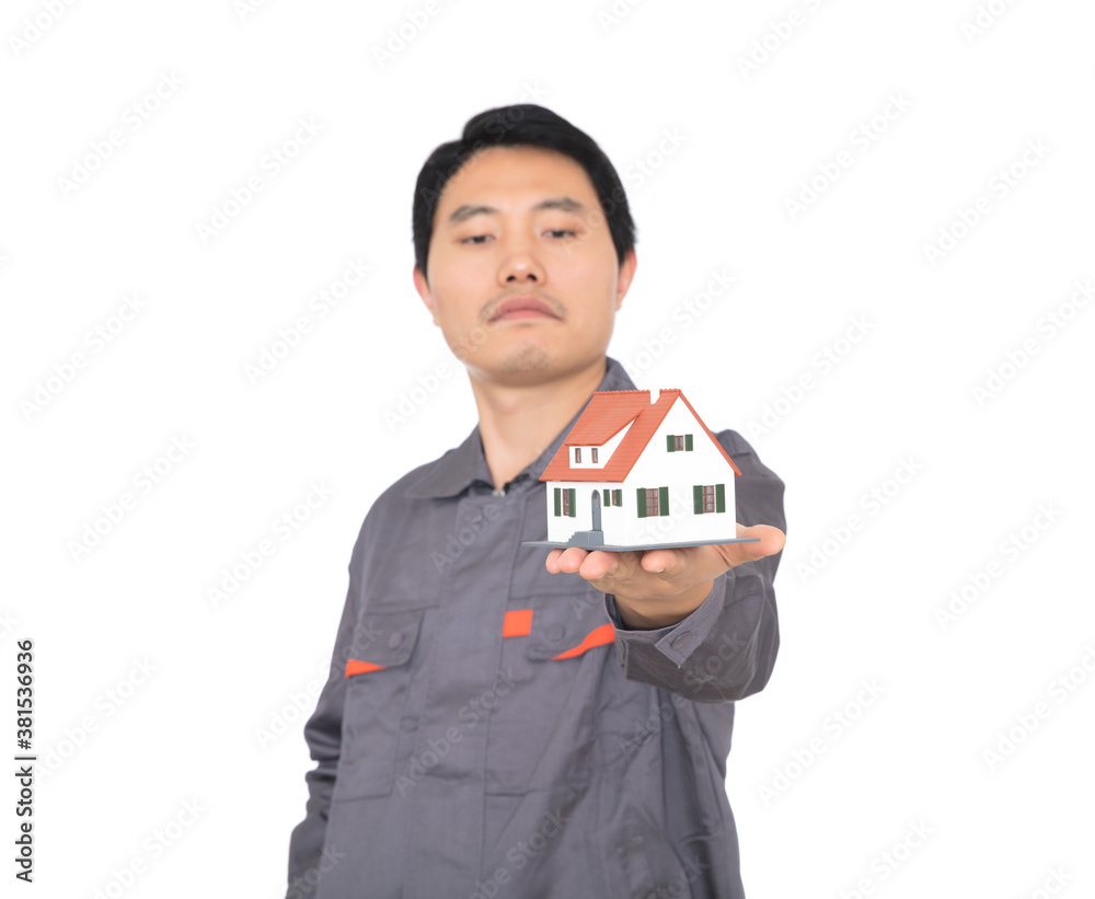 Young Chinese worker in overalls holding a small house model Young Chinese worker in overalls holding a small house model