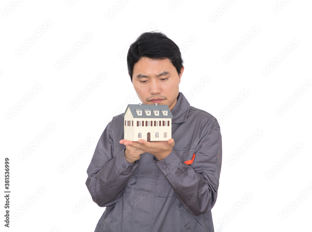 Young Chinese worker in overalls holding a small house model Young Chinese worker in overalls holding a small house model
