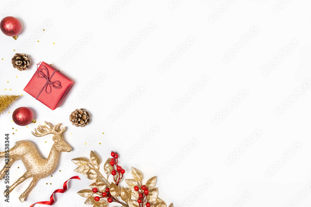 Christmas background - gift box, mistletoe, fircones,reindeer and christmas balls in golden and red colors over white background. Copy space, flat lay.