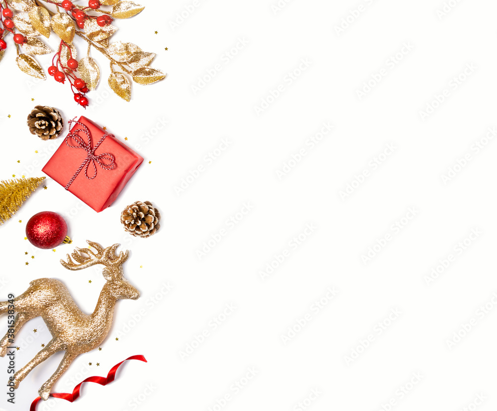 Christmas background - gift box, mistletoe, fircones,reindeer and christmas balls in golden and red colors over white background. Copy space, flat lay.