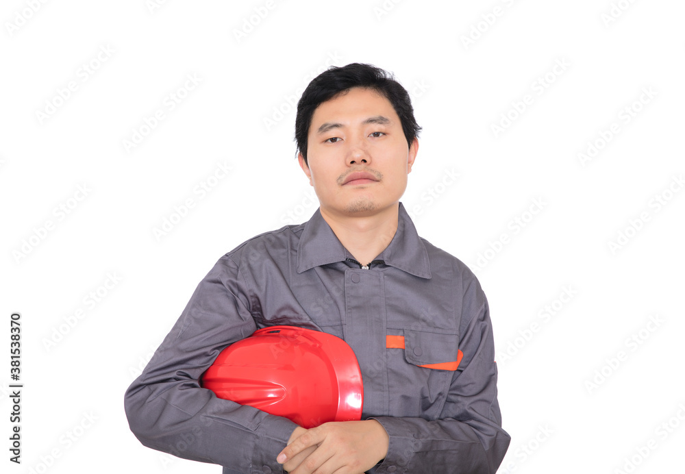 Confident young worker holding red hard hat in hand and standing in front of white background Confident young worker holding red hard hat in hand and standing in front of white background