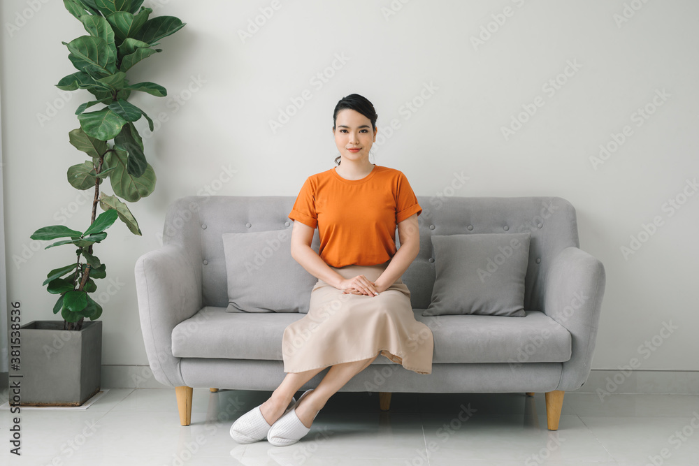 Yuong woman sitting on her white sofa