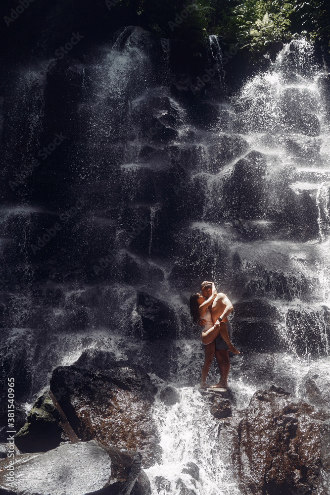 Fototapeta premium Couple under waterfall. People on vacation. Bali theme.