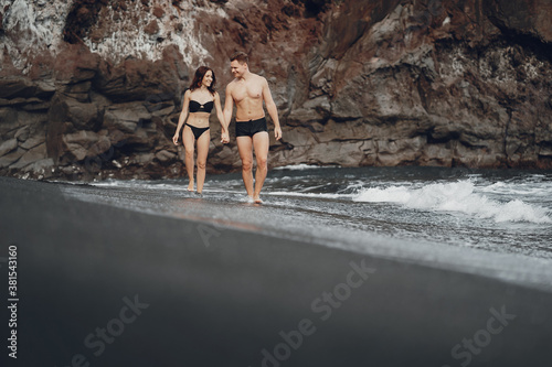 couple relaxing at a secluded private beach in Bali Indonesia. couple showing affection on a hidden beach. Couple wearing bathingsuits