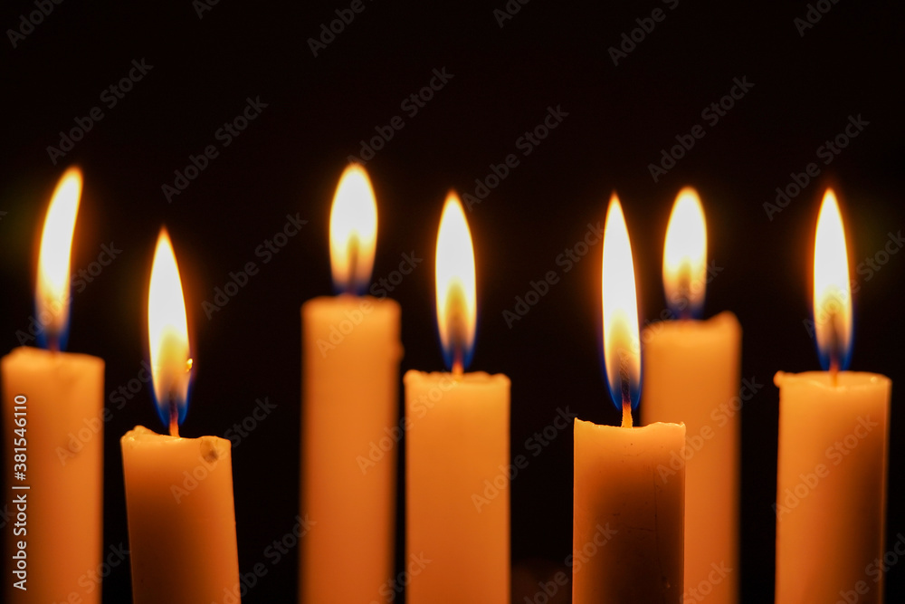 Close up photo of group candlelight in the dark, close up of burning candles in the dark.