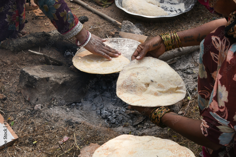 Village Roti Making Indian woman making Indian flat bread tandoori roti with hand in ...