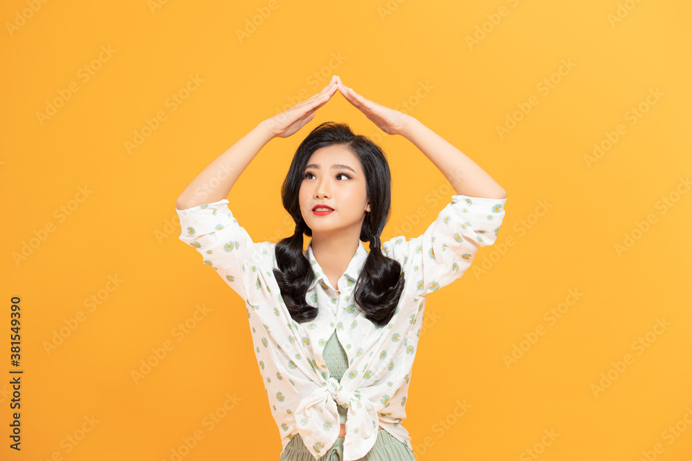 Photo of nice pleased woman in raincoat making roof gesture and smiling isolated over white background Photo of nice pleased woman in raincoat making roof gesture and smiling isolated over white background