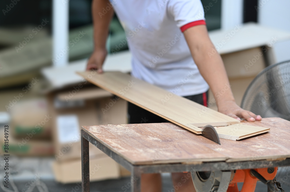 Cropped shot of carpenter cutting a piece of wood in his woodwork workshop. Cropped shot of carpenter cutting a piece of wood in his woodwork workshop.